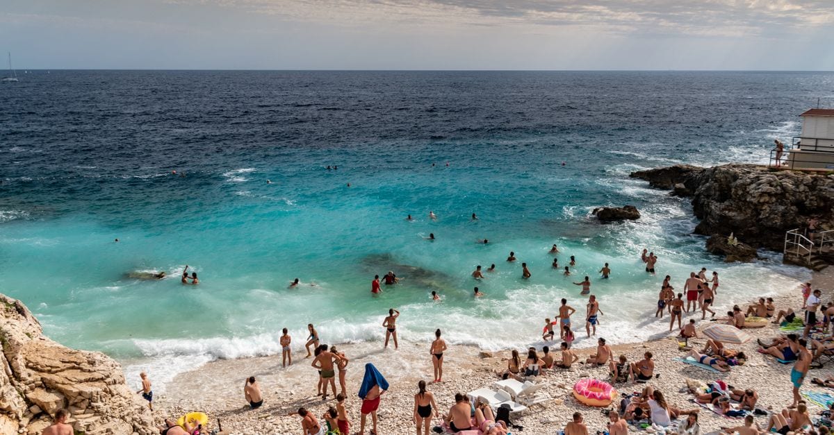 Families on the pebble shore of Hawaii Beach in Pula